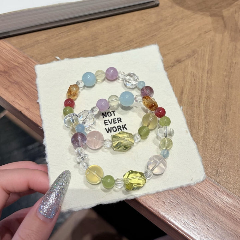 Handmade multicolor crystal bracelet featuring citrine and clear quartz beads, held in hand.