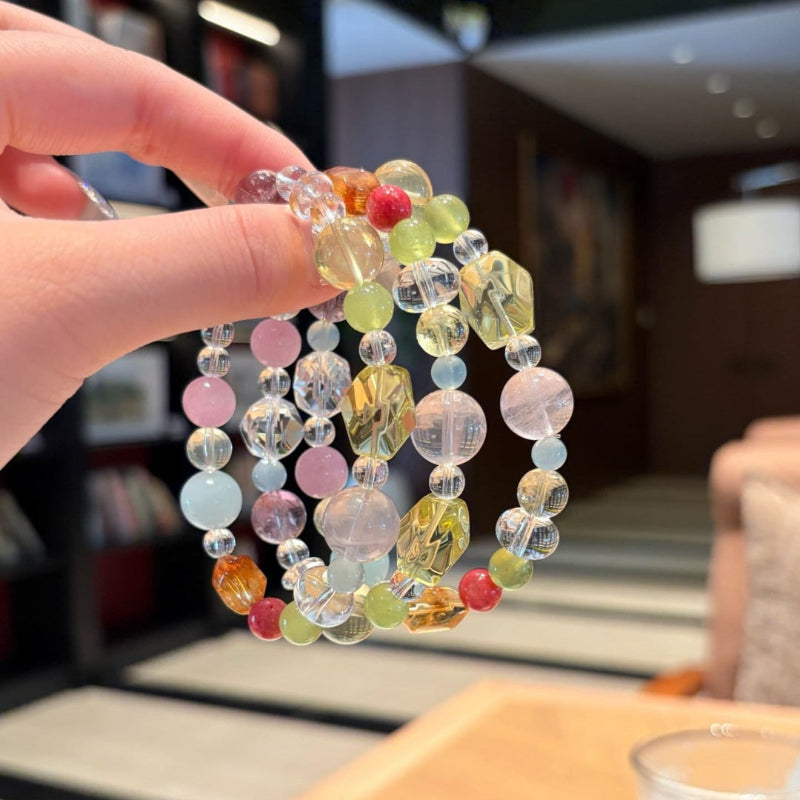 Handmade multicolor crystal bracelet featuring citrine and clear quartz beads, held in hand