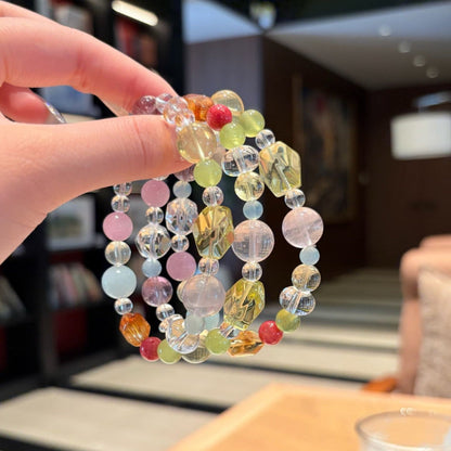 Handmade multicolor crystal bracelet featuring citrine and clear quartz beads, held in hand