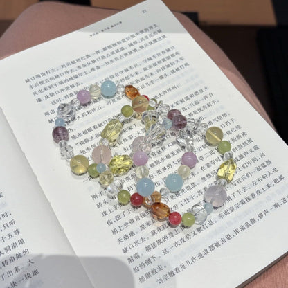 Handmade multicolor crystal bracelet featuring citrine and clear quartz beads, held in hand.