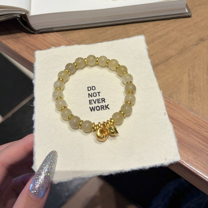 Handmade gold rutile beaded bracelet with natural healing crystal beads, held in hand for display