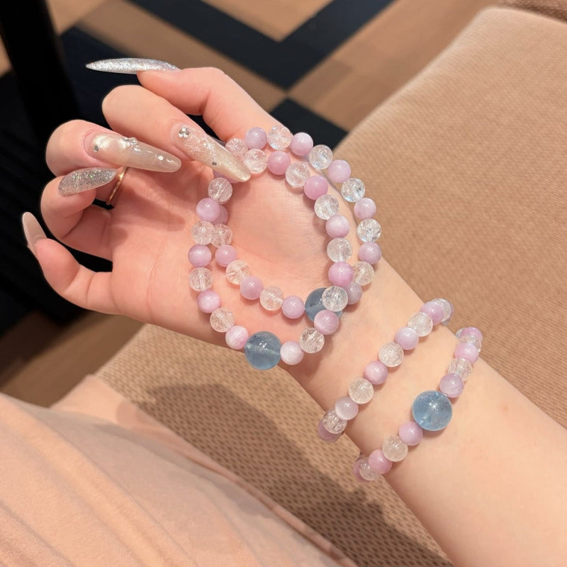 Handmade purple spodumene and aquamarine crystal bracelet, held in hand for display