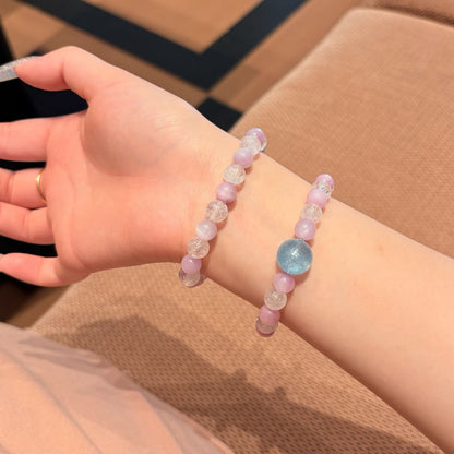 Handmade purple spodumene and aquamarine crystal bracelet, held in hand for display