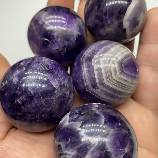 Bulk Chevron Amethyst Crystal Spheres Held In Hand