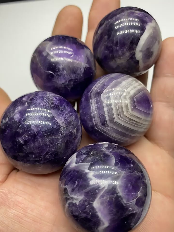 Bulk Chevron Amethyst Crystal Spheres Held In Hand