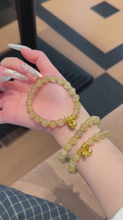 Handmade gold rutile beaded bracelet with natural healing crystal beads, held in hand for display