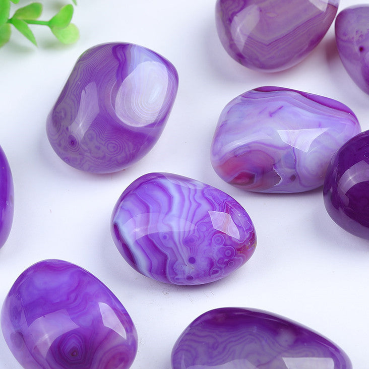 Close up of swirling banding pattern on purple lace agate tumbled stone