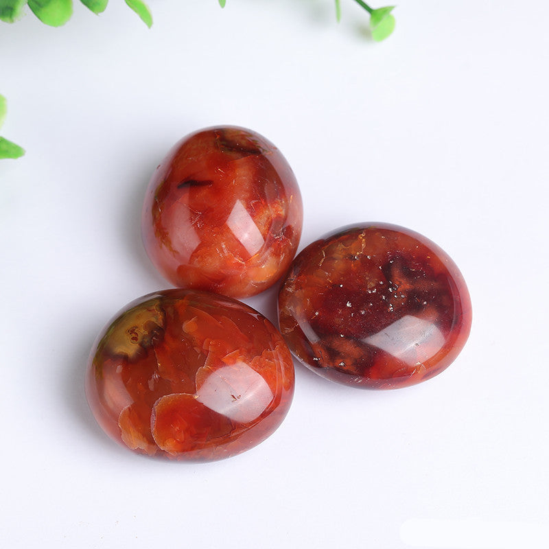 Natural texture detail of red agate tumbled palm stone, bulk crystal supply