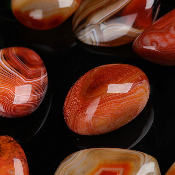 Close up of swirling red brown banding on natural lace agate palm stone