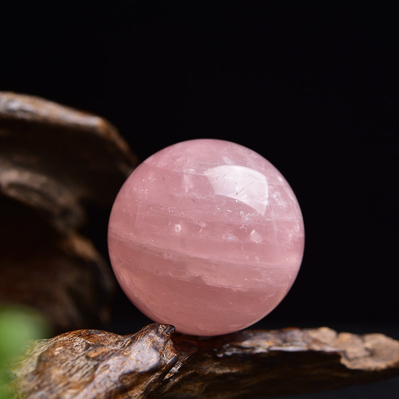 Close up of natural deep pink rose quartz crystal sphere, natural stone with mineral veins